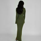 Person wearing a green knit lounge corset dress against a white background