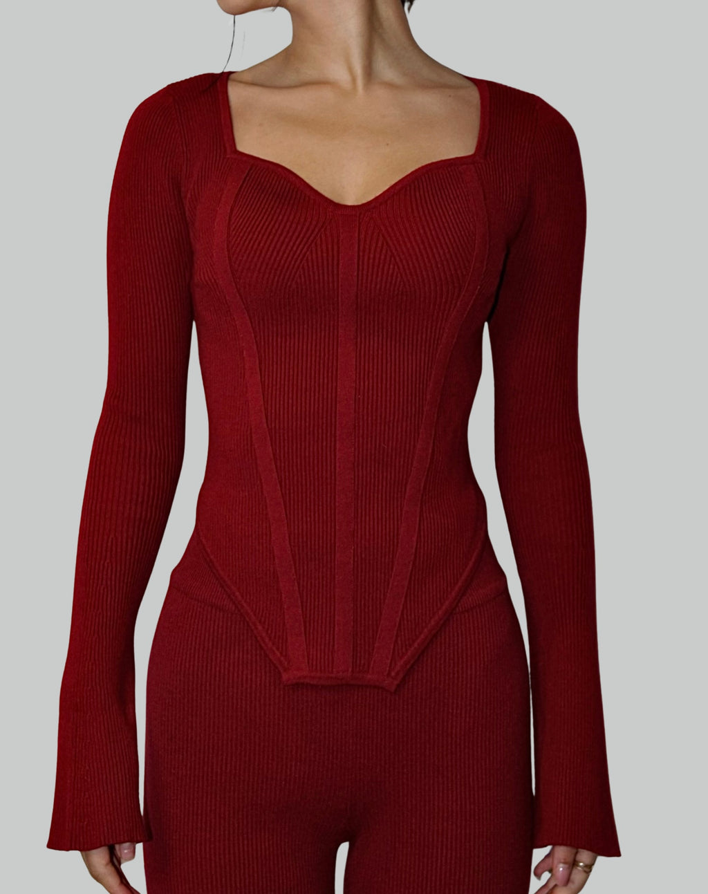 Red knit ribbed lounge long-sleeve with sweetheart neckline and corset detail top on a plain background