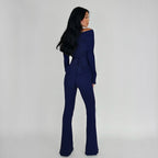 Woman wearing a navy blue jumpsuit against a plain background