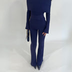 Navy blue knit lounge jumpsuit with long-sleeve foldable top and flared pants on a white background