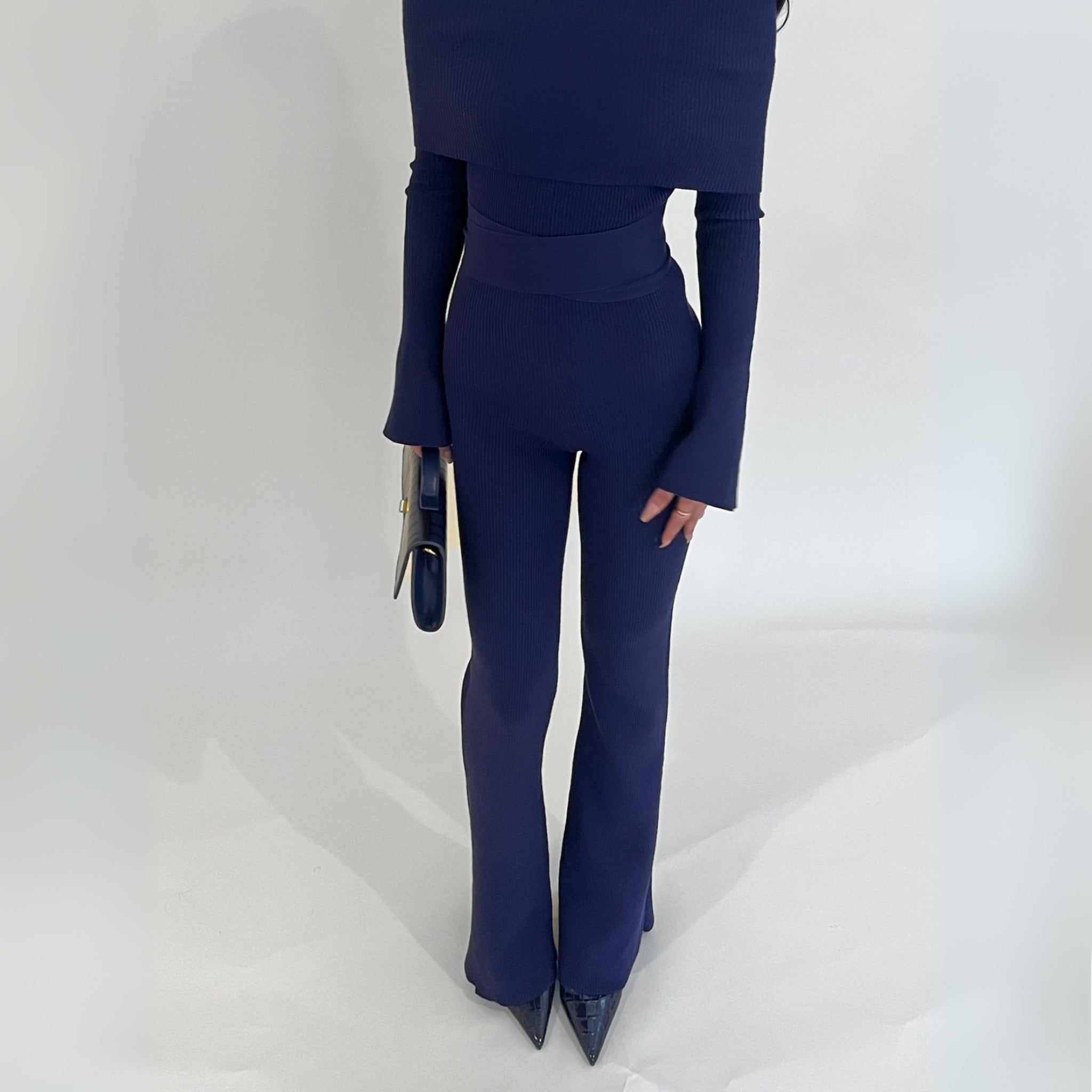 Navy blue knit lounge jumpsuit with long-sleeve foldable top and flared pants on a white background