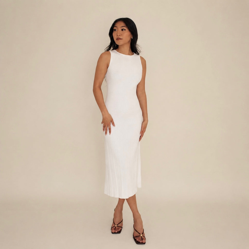 Woman wearing a white lounge sleeveless dress against a beige background