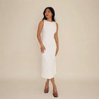 Woman wearing a white lounge sleeveless dress against a beige background